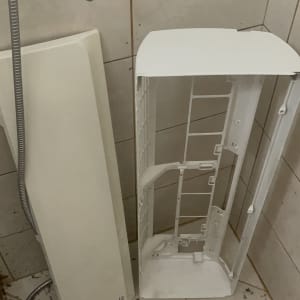 חלקי מזגן מפורקים על רצפת חדר אמבטיה