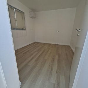 התקנת פרקט למינציה בגוון עץ בהיר בחדר