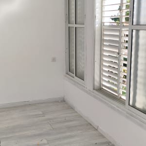 קיר וחלון בחדר עם רצפת עץ