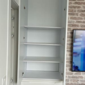 ארון לבן עם מדפים ודלתות פתוחות