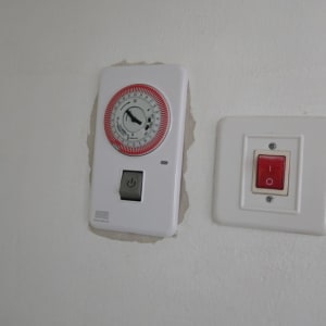 שעון טיימר ומתג על קיר לבן