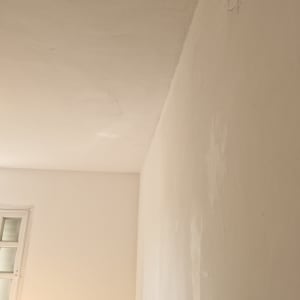 קיר ותקרה צבועים בלבן עם חלון קטן