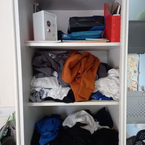 ארון בגדים עם בגדים מקופלים ומסודרים