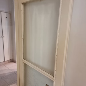 דלת עץ עם זכוכית חלבית במסגרת עליונה