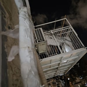 יחידת מזגן חיצונית מותקנת על מרפסת בלילה