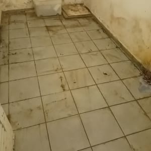 רצפה מלוכלכת עם כתמים וקירות מתקלפים