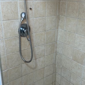 מקלחת עם אריחים וראש מקלחת מתכת