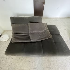 ספה אפורה עם כריות ורובוט שואב אבק