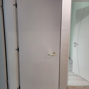 דלת עם ידית זהב על רקע קיר לבן