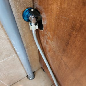 ברז מים עם צינור מחובר לקיר עץ