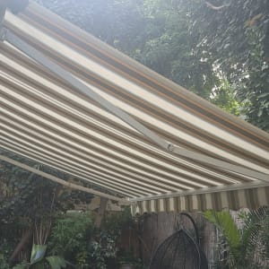 סוכך זרועות בגינה עם צמחייה מסביב