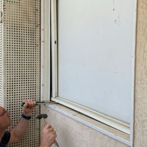 אדם עובד על חלון עם כלים