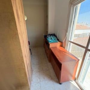 חדר ריק עם רהיטים מעץ ואור שמש נכנס מהחלון