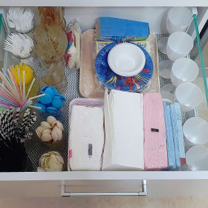 מגירה מאורגנת עם כלים חד פעמיים, כוסות וצלחות.