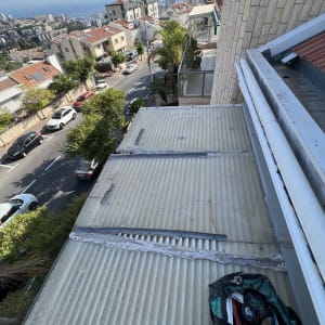 גג עם יריעות פלסטיק וכלי עבודה מונחים בצד