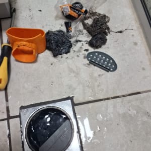 כלי עבודה לניקוי סתימה בביוב על רצפה רטובה