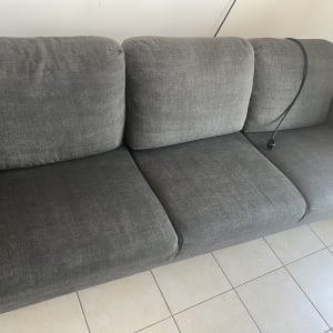 ספה אפורה עם כבל חשמל על רצפת אריחים