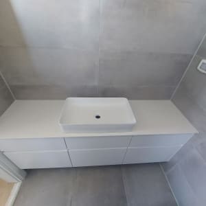 כיור על משטח שיש לבן בחדר אמבטיה