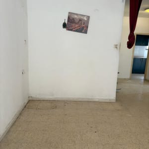 קיר ריק עם תמונה תלויה, וילון אדום בצד