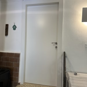 דלת לבנה עם ידית מתכת ומנעול