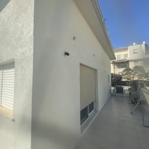 קיר חיצוני של מבנה עם חלון ותריס סגור