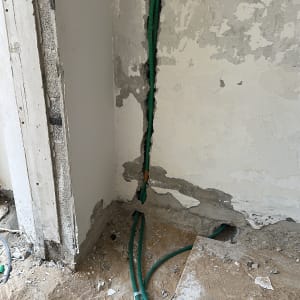 קיר עם חוטי חשמל חשופים ושקע