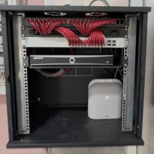 ארון תקשורת עם כבלים אדומים וציוד רשת