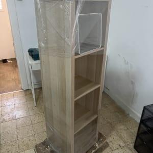ארון עץ עטוף בניילון על עגלת הובלה