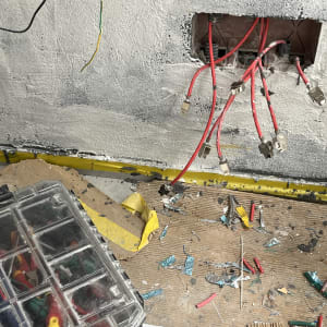 כבלים אדומים מחוברים לשקע בקיר, קופסת כלים פתוחה