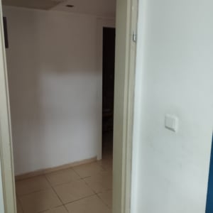 דלת פתוחה עם משקוף בהיר וקיר לבן