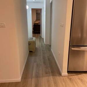 רצפת פרקט עץ במסדרון ביתי מואר