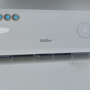 מזגן קיר לבן עם תצוגה דיגיטלית וטמפרטורה 16