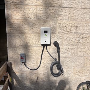 עמדת טעינה לרכב חשמלי על קיר אבן חיצוני