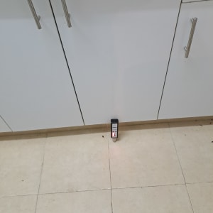 מכשיר איתור נזילות על רצפה ליד ארון מטבח