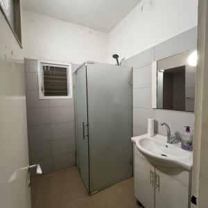 מקלחון עם כיור ומראה בחדר אמבטיה