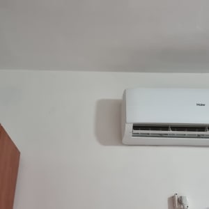 מזגן מותקן על קיר עם חוטי חשמל