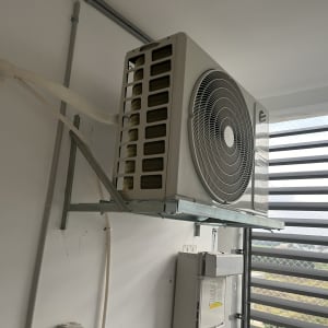 יחידת מזגן חיצונית מותקנת על קיר עם צינורות