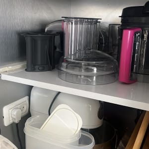 מדפים עם מכשירי מטבח וכלי פלסטיק