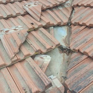 רעפים שבורים על גג עם חלון פתוח