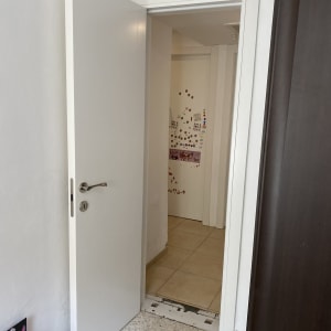 דלת לבנה פתוחה עם ידית כסופה