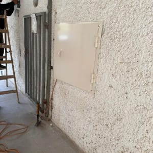 אדם על סולם מתקין מסגרת על קיר חיצוני