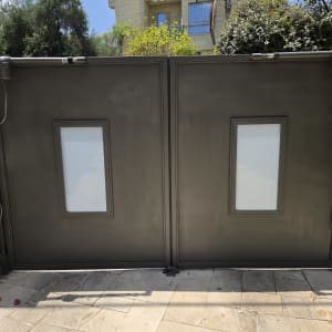 שער מתכת עם חלונות זכוכית מול בית