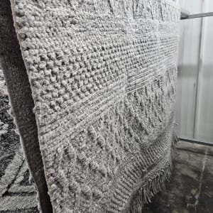 שטיח אפור תלוי לייבוש לאחר ניקוי