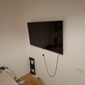 טלוויזיה מותקנת על קיר עם כבלים חשמליים