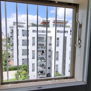 חלון עם סורגים ומנגנון פתיחה בצד ימין