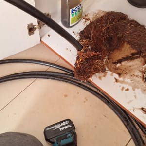 כלי עבודה וצינור ליד סתימה מתחת לכיור