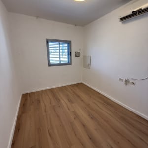 חדר עם רצפת פרקט, חלון ומזגן