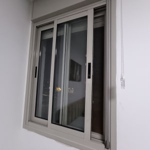 חלון עם תריסים פנימיים סגורים ומסגרת מתכתית