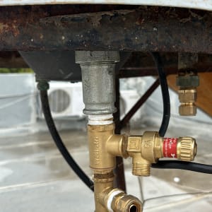 צנרת מתכת עם ברזים וחיבורים מתחת לדוד