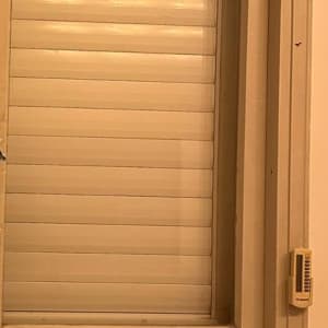 חלון זכוכית עם תריס סגור ונורות תלייה